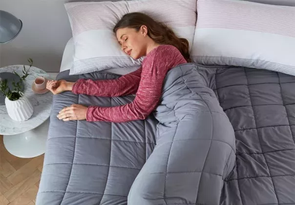 Woman asleep in bed with a weighted blanket