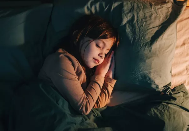 Child sleeping comfortably in bed before returning to school